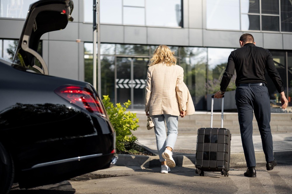 chauffeur-helps-businesswoman-carry-her-suitcase-into-building-walking-together-luxury-taxi-front-concept-business-trips-idea-luxury-car-transfer-service